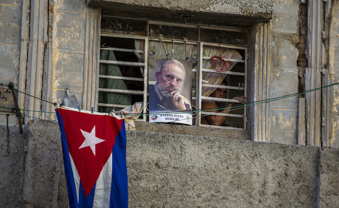 Una fotografía de Fidel Castro y la bandera cubana decoran una casa en La Habana, Cuba, el domingo 27 de noviembre de 2016. Los cubanos fueron convocados el lunes y martes a la Plaza de la Revolución para mostrar sus condolencias por su muerte. (AP Foto/Desmond Boylan)