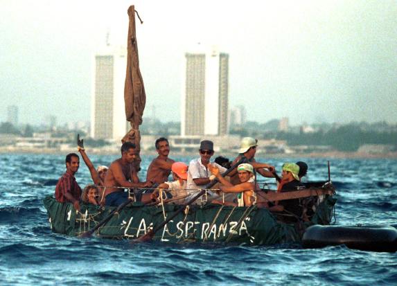 **FILE** Cubans leave the coast in a raft  in this August 1994 file photo in Havana Cuba during the 1994 massive exodus. In mid-August 1994, after a string of boat hijackings, unprecedented rioting and the killing of a Cuban navy lieutenant prompted President Fidel Castro to suggest that those wanting to leave, could.  Over about five weeks, more than 30,000 Cubans took Castro at his word and sailed away on makeshift rafts while authorities stood by.(AP Photo/Jose Goitia, file)The words on the raft read: "Hope" (AP Photo/Jose Goitia, file)